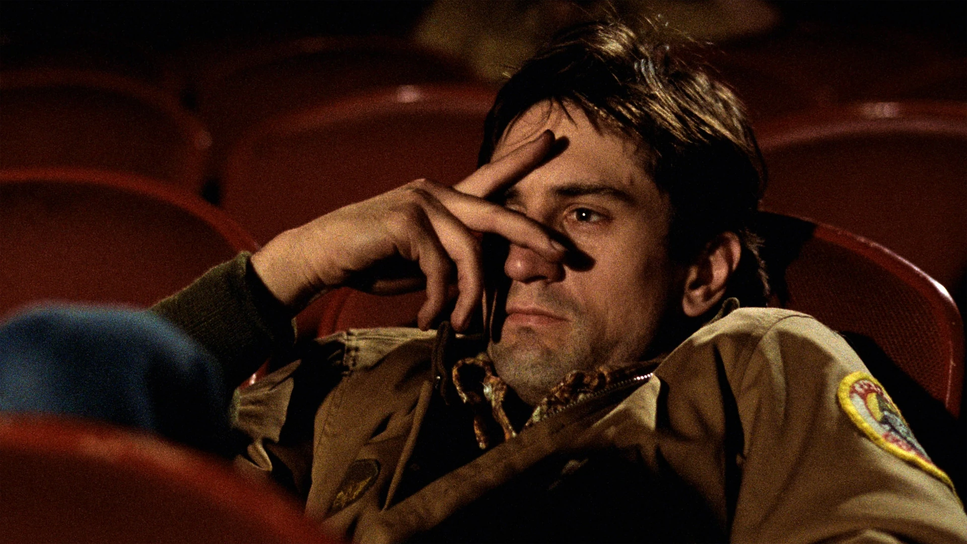 Travis Bickle, alone in his taxi, illuminated by the city's neon glow