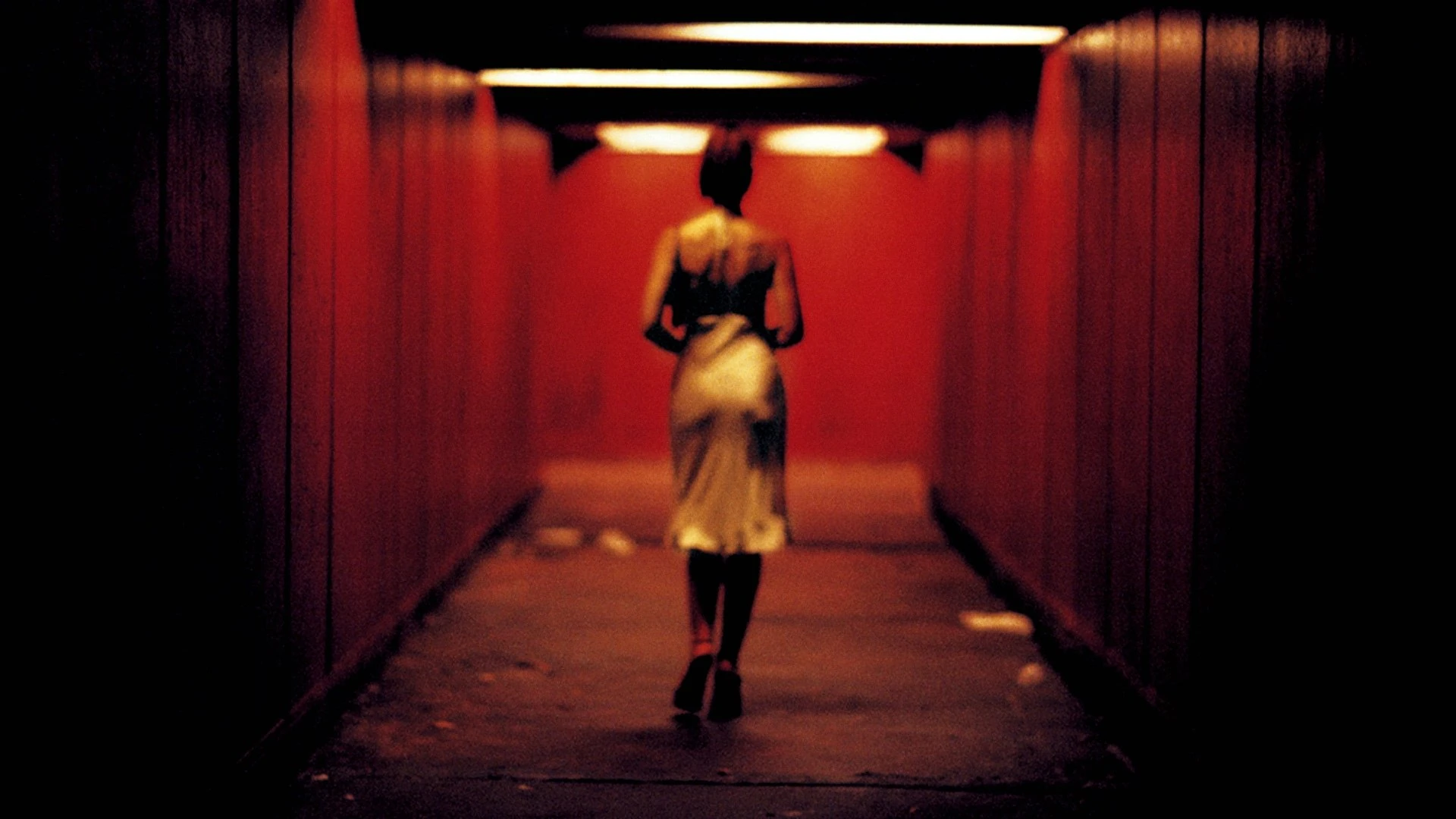 A man's face illuminated by red light, expressing intense emotion in Irreversible